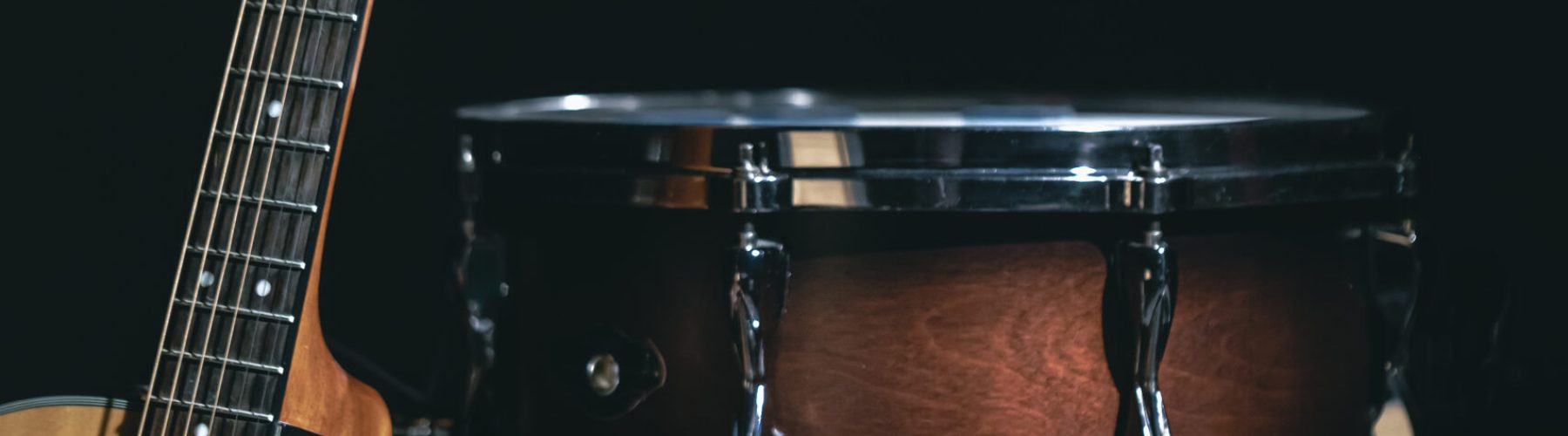 Acoustic guitar and snare drum on black background isolated, music concert concept.